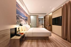 a bedroom with a bed and a flat screen tv at Atour Hotel Shenyang South Station Quanyun Road in Shenyang