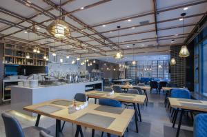哈爾濱的住宿－哈尔滨哈西高铁站亚朵酒店，餐厅设有木桌、椅子和柜台