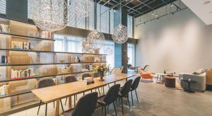 eine Bibliothek mit einem Tisch, Stühlen und Bücherregalen in der Unterkunft Atour Hotel Ningbo Sanjiangkou Bund Book City in Ningbo