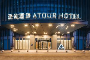 a hotel with a sign on the front of it at Atour Hotel Tianjin Binhai High Speed Railway Station in Binhai