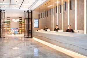 a group of people sitting at a counter in a lobby at Atour Hotel Guiyang Guanshan Lake Park in Guiyang