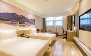ein Hotelzimmer mit 2 Betten und einem Flachbild-TV in der Unterkunft Atour Hotel Hefei South Station Binhu Convention and Exhibition Center in Hefei