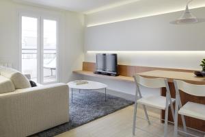 a living room with a couch and a table with a tv at Mur by Feelfree Rentals in San Sebastián
