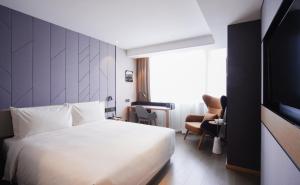 a hotel room with a bed and a television at Atour S Hotel Guangzhou Tianhe Taikoo Hui in Guangzhou