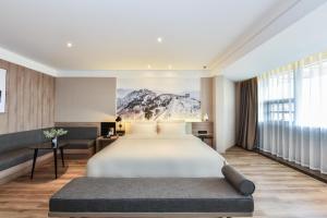 a bedroom with a large bed and a large window at Atour Hotel Tianjin Binhai 1st Street in Binhai