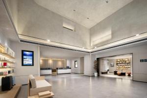 a large room with a lobby with couches and a television at Atour Hotel Tianjin Zhongbei Haitai Industrial Park in Tianjin