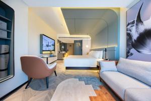 um quarto de hotel com uma cama e um sofá em Atour S Hotel Ningbo Zhoushan East Road em Ningbo