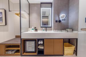 W łazience znajduje się umywalka i lustro. w obiekcie Atour Hotel Beijing South Xizhan Road w Pekinie