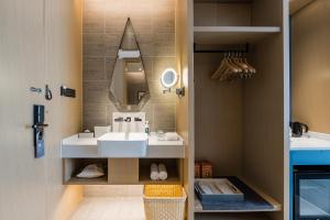 W łazience znajduje się umywalka i lustro. w obiekcie Atour Hotel Handan New Century w Handan