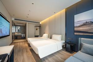 a bedroom with two beds and a flat screen tv at Atour Hotel Shanghai Huajing in Shanghai