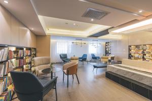 une bibliothèque avec des chaises, des tables et des livres dans l'établissement Atour Hotel Lanzhou Dongfanghong Plaza, à Lanzhou