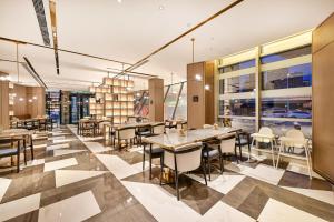 a restaurant with tables and chairs in a building at Atour Hotel Tianjin Eye in Tianjin