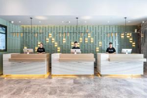 three people sitting at a counter with their laptops at Atour Hotel Wuhan Tiandi Hankou Jiangtan in Wuhan