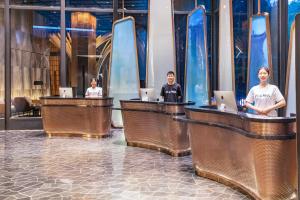 a group of people sitting at the reception desks of a hotel at Atour S Hotel Zhuhai Gongbei Port NetEase Selected in Zhuhai