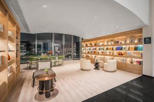 a library with white chairs and tables and books at Atour Hotel Chengdu High Tech West District Government Affairs Center in Chengdu