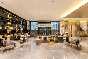 a lobby with chairs and tables and wine bottles at Atour Hotel Beijing Dahongmen Yintai in Beijing