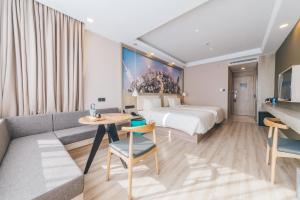 a hotel room with a bed and a couch at Atour Hotel Shanghai Pudong Zhangjiang Park in Shanghai