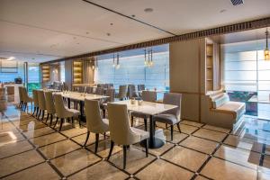 a restaurant with tables and chairs in a room at Atour X Hotel Dongguan Chang'an Wanda in Dongguan