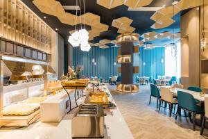 a restaurant with blue ceilings and tables and chairs at Atour Hotel Ningbo International Convention and Exhibition Center in Ningbo