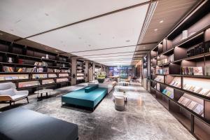 a library with a blue couch and bookshelves at Atour Hotel Taian Taishan Internation Convention and Exhibition Center in Tai'an