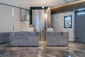 two women sitting at reception desks with their laptops at Atour Hotel Shenyang Zhongshan Plaza in Shenyang