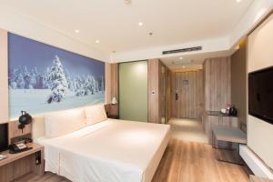 Atour Hotel Harbin Songbei Ice and Snow World في هاربين: غرفة نوم بسرير ابيض كبير وتلفزيون