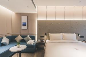 a hotel room with a bed and a couch at Atour S Hotel Chongqing Crown International in Chongqing