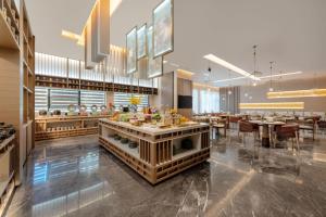 a restaurant with tables and chairs and a buffet at Atour Hotel Karamay in Karamay