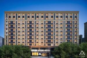un gran edificio con luces encendidas en una ciudad en Atour Hotel Urumqi Airport Degang Wanda, en Ürümqi