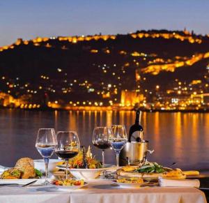 a table with wine glasses and food on top of it at Anjeliq House Boutique Hotel in Alanya