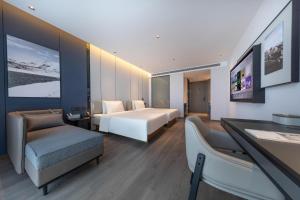 a hotel room with a bed and a desk and chairs at Atour Hotel Beijing Capital Airport New International Exhibition Center in Beijing