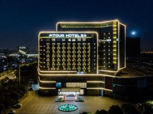 a night view of a hotel in a city at Atour Hotel Changzhou Wujin Science and Education City in Changzhou