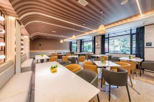 a restaurant with tables and chairs and windows at Atour Hotel Quanzhou Hongchang Baozhou Road in Quanzhou