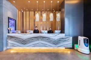 zwei Personen sitzen mit ihren Laptops an einem Schreibtisch in der Unterkunft Atour Hotel Ningbo Sanjiangkou Bund Book City in Ningbo