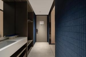 uma casa de banho com um lavatório e uma parede azul em Atour Light Hotel Jinan Harmony Square Provincial Hospital em Jinan