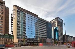 a large building in a city with tall buildings at Atour Hotel Shenyang Railway Station Taiyuan Street in Shenyang