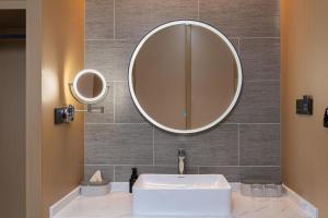 a bathroom with a sink and a mirror on the wall at Atour Hotel Kunming Changshui International Airport in Kunming