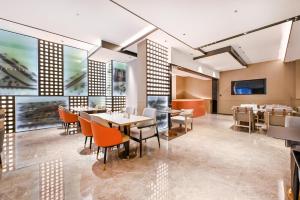 a dining room with tables and chairs and a tv at Atour Hotel Shenyang Nanta Wenhua Road in Shenyang