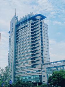 ein großes Gebäude mit seitlicher Uhr in der Unterkunft Atour Hotel Hangzhou Xiaoshan Peoples Square in Hangzhou