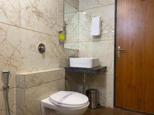 a bathroom with a toilet and a sink at Hotel Heera Residency in Bhopal