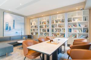 a library with a table and chairs and bookshelves at Atour Hotel Shanghai Xianxia in Shanghai