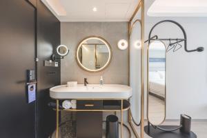 a bathroom with a sink and a mirror and a bed at Atour Light Hotel Hangzhou Xiasha in Hangzhou +50 photos