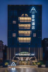 ein Hotel mit einem Schild an der Seite eines Gebäudes in der Unterkunft Atour Hotel Fuzhou Wusi Road Hot Spring Park in Fuzhou