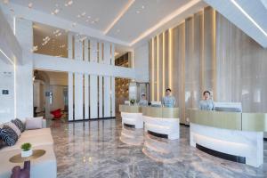 a lobby with people sitting at desks in a building at Atour Hotel Hefei North Square South Station in Hefei