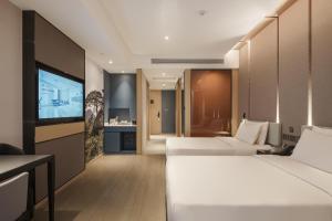 a hotel room with two beds and a flat screen tv at Atour Hotel Taian Taishan Scenic Area Pangu Tiandi in Tai'an