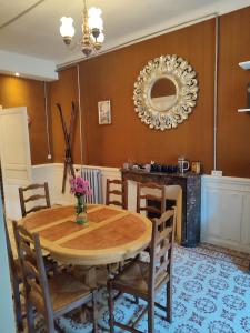 uma sala de jantar com uma mesa, cadeiras e um espelho em La Scierie em Quillan
