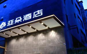 un bâtiment bleu avec des écritures sur son côté dans l'établissement Atour Hotel Dalian Zhongshan Square, à Dalian