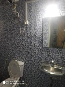 a bathroom with a sink and a toilet and a mirror at Bethel Guesthouse Panaji in Panaji