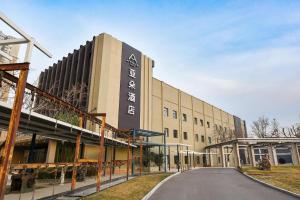 un edificio con un cartel en el costado en Atour Hotel Beijing Wangjing 798 Art District en Beijing