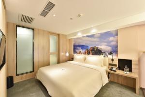 a bedroom with a large bed with a painting on the wall at Atour Hotel Beijing Yizhuang Mobile Silicon Valley in Daxing